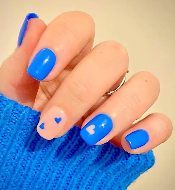 Short blue nails along with negative spaced minimal nail art and heart accent