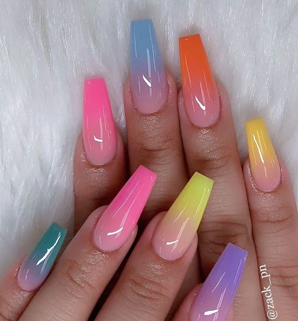 a group of hands with long ombre nails