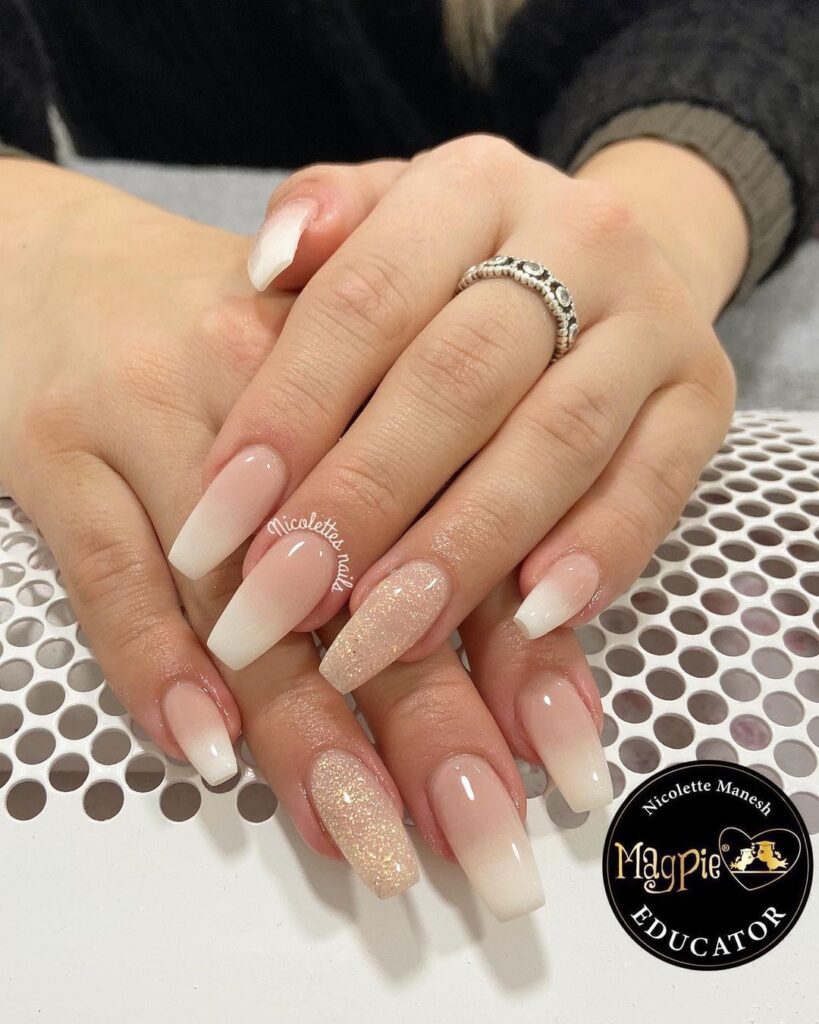 a close up of a hand with long ombre nails