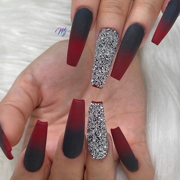 Red and black matte ombre nails along with the ring finger nail full of rhinestones