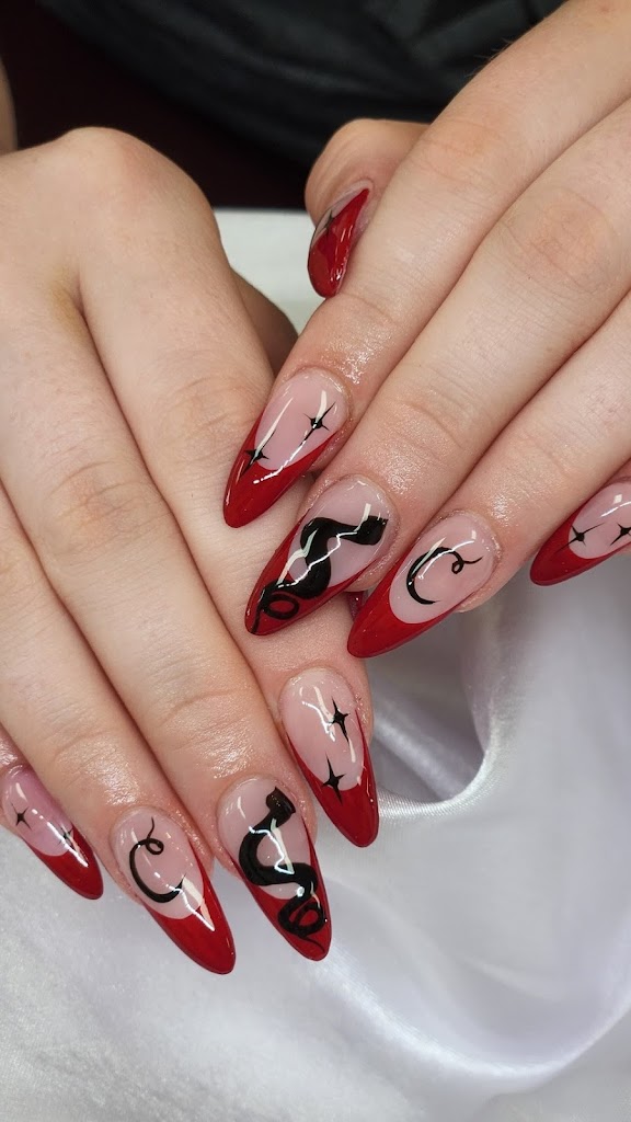 two hands with nails. Nails are adorned with french tip in red color and have snaky accents in black color for a horrorfull experience. 