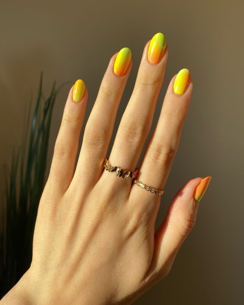 Ombre nail art using bright citrus nail colors like orange, yellow and neon green 