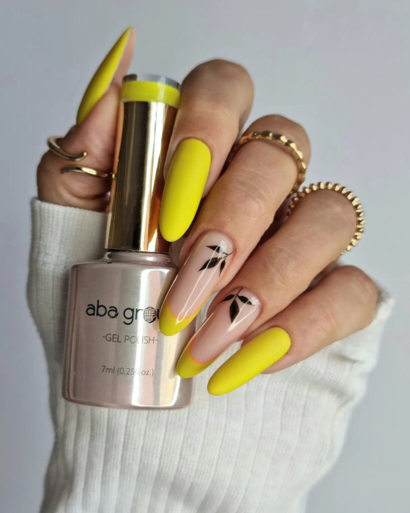 Long bright yellow nails with little leaves painted as in fall