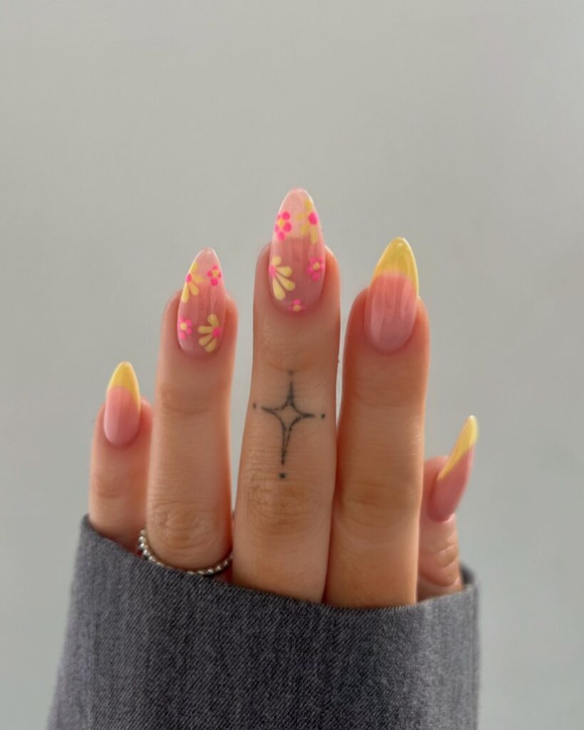 a hand with fingers stretched showing Khaki yellow nails with pastel pink floral designs