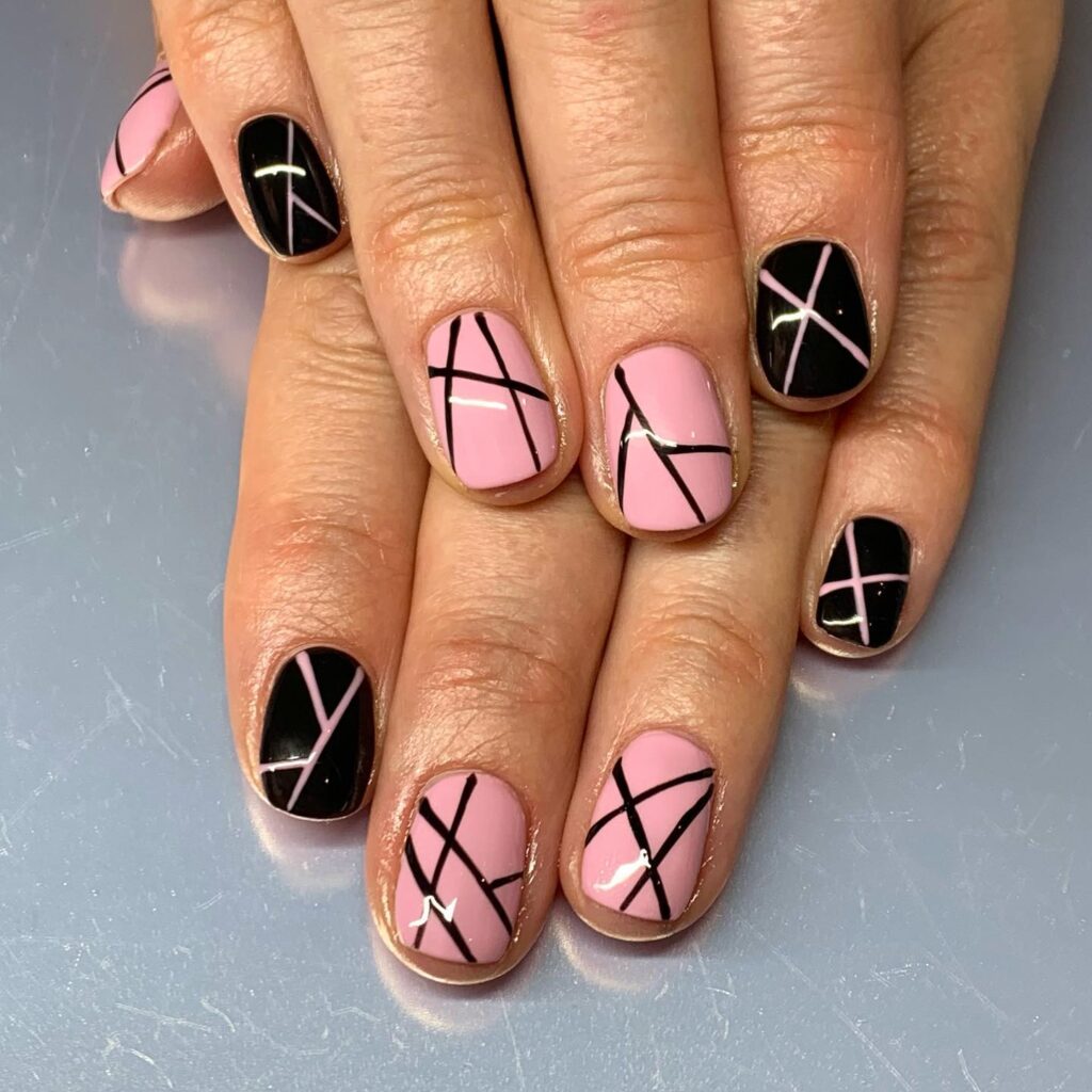 Baby pink and black nail art using lines appearing as it is color blocked 