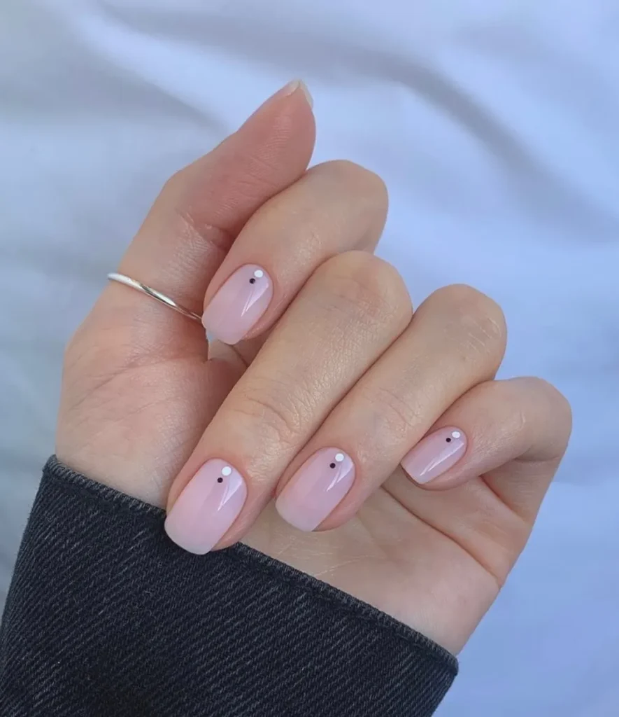 Soft pastel pink nails with little back dot on the bottom