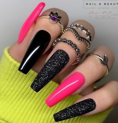 Hands with long pink and black coffin nails where three nails are glossy while two are textured