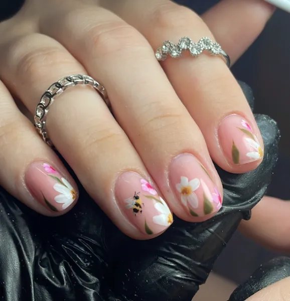 Short nails with floral designs and a little bee