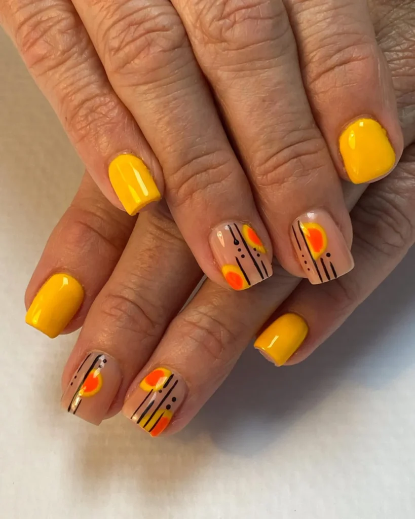 nail art design that features a combination of yellow and orange tones with a geometric pattern.