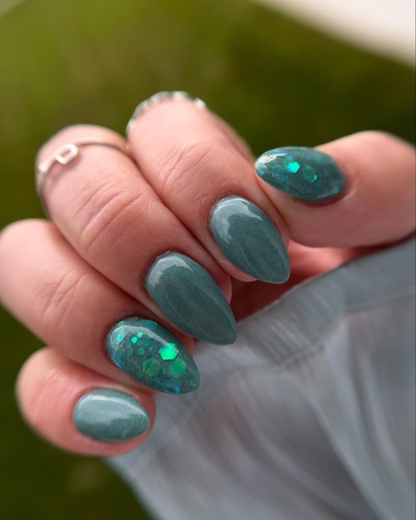 Nexgen dip manicure almond nails in color teal along with glitter chunks 