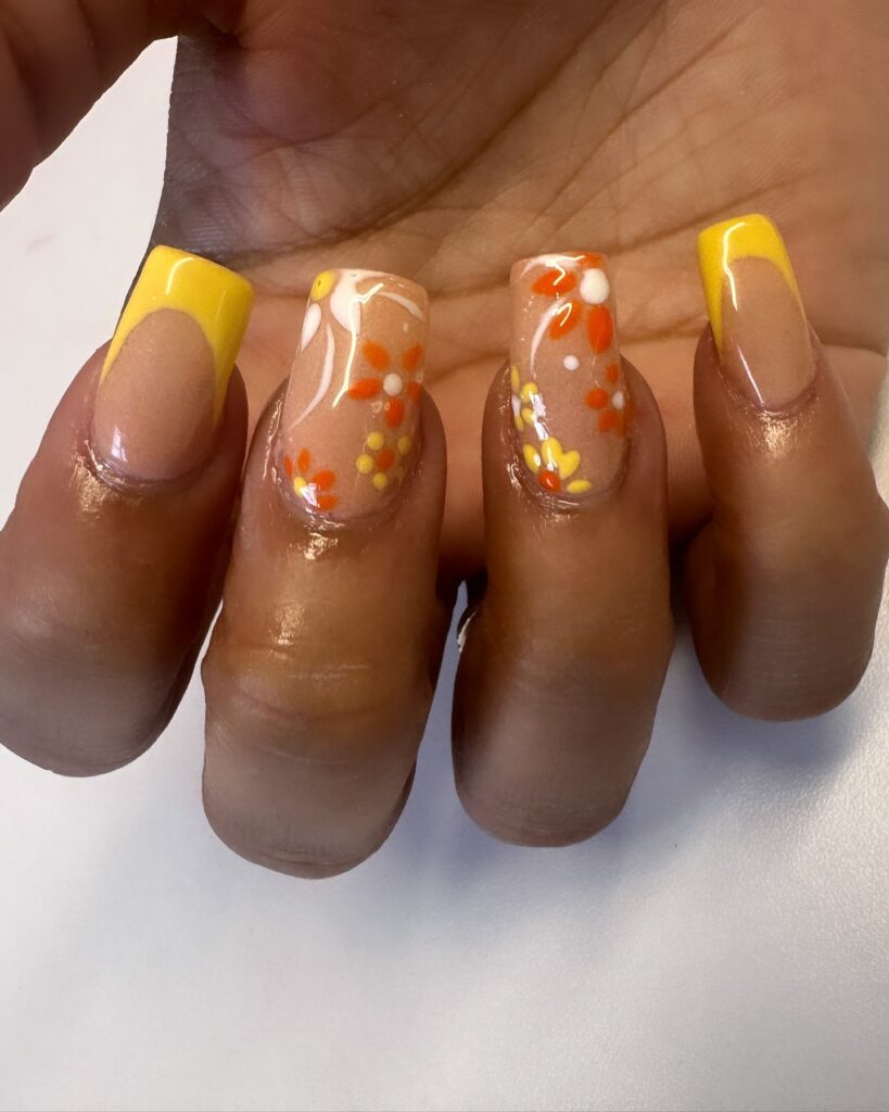 Nails with yellow french tip and floral details