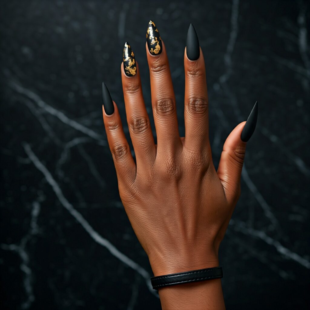 Gold foil nail art on matte black stiletto nails