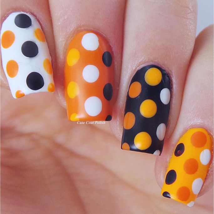 Orange, black, and white polka dot nail art