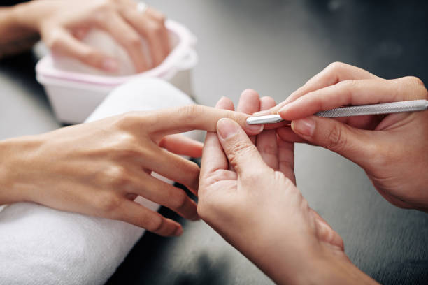 A women pushing back her nail cuticles 