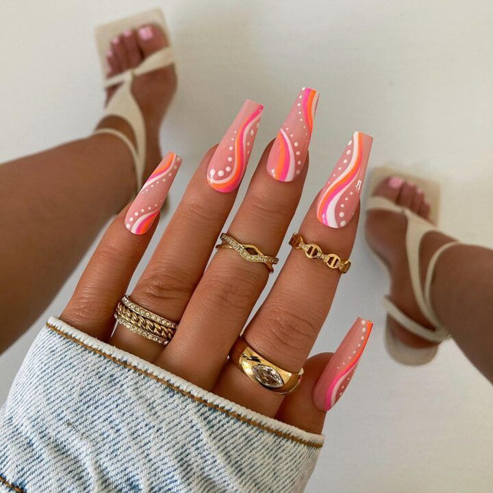 Pink, orange, and white nails with swirls and dots