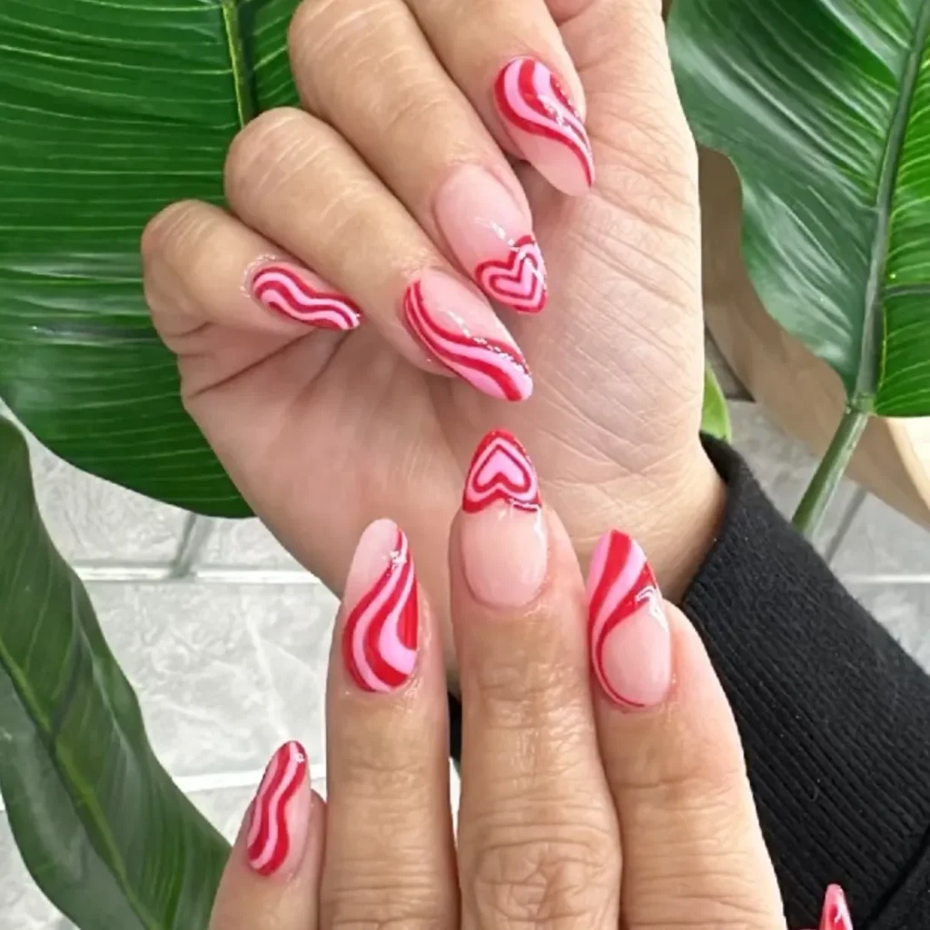 Red and pink manicure with swirls and hearts