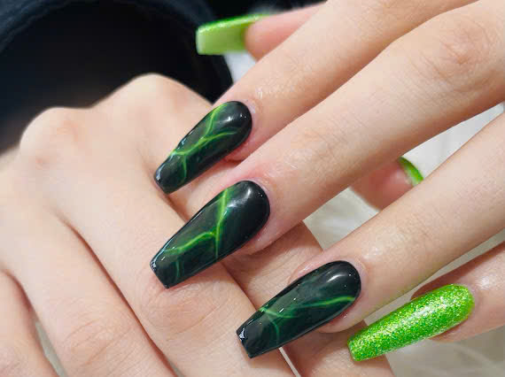 Neon green and black marble nails in coffin shape