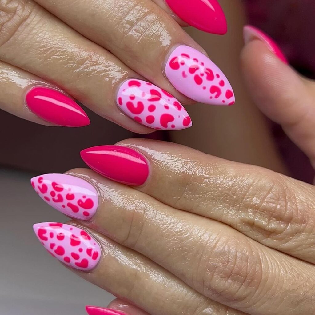 Short, pointed nails with a bright pink base and darker pink leopard spots