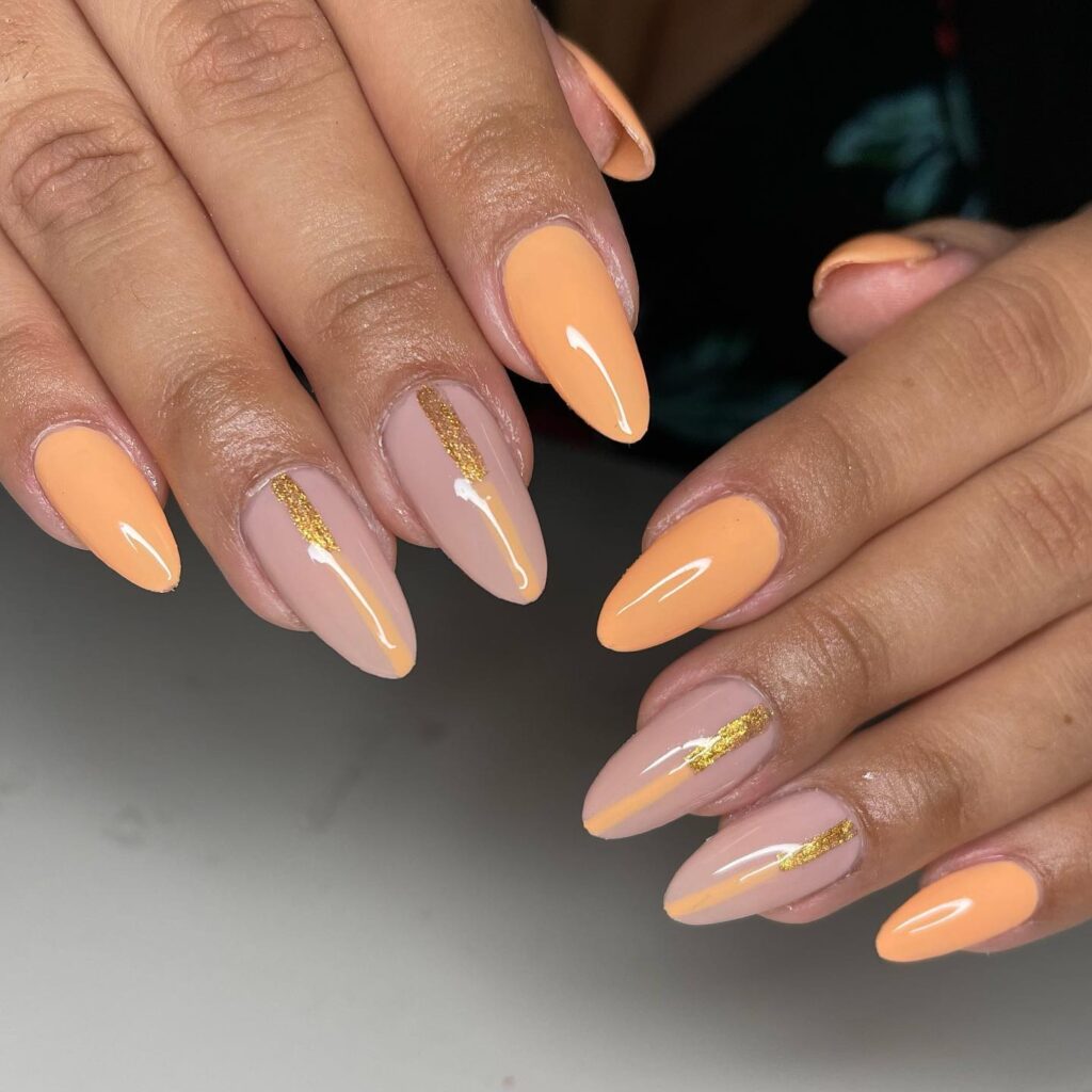 Pastel orange nails with glitter line accent