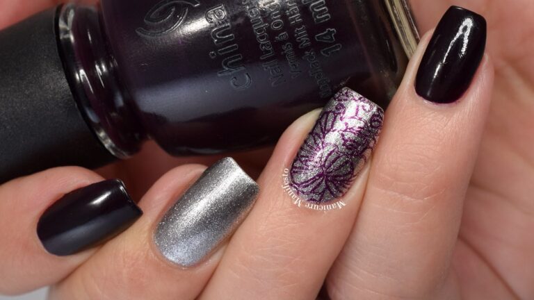 Dark plum purple nails with an intricate silver metallic stamped design on an accent nail