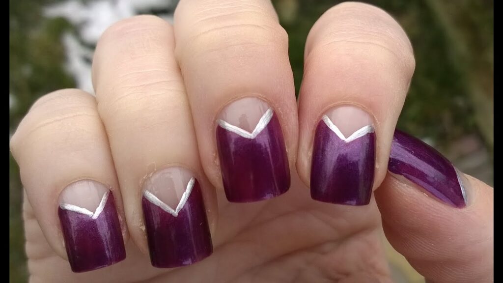 Modern purple nails with a sharp metallic silver V-shaped French tip