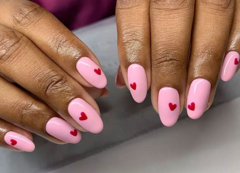 Pink oval nails with red hearts