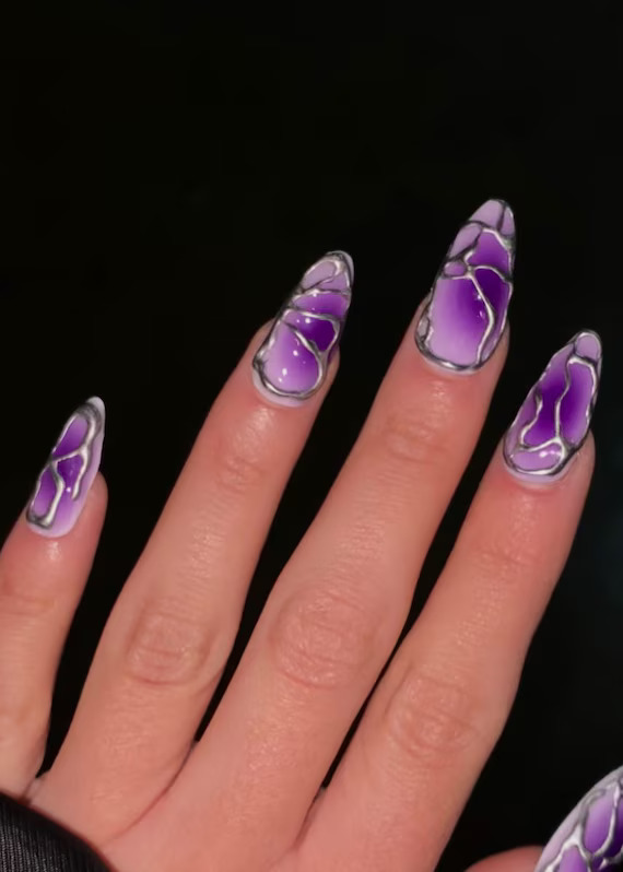 Purple nails with a silver shattered glass or mosaic pattern over a gradient base