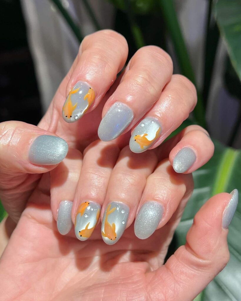 Shimmery grey nails with goldfish art