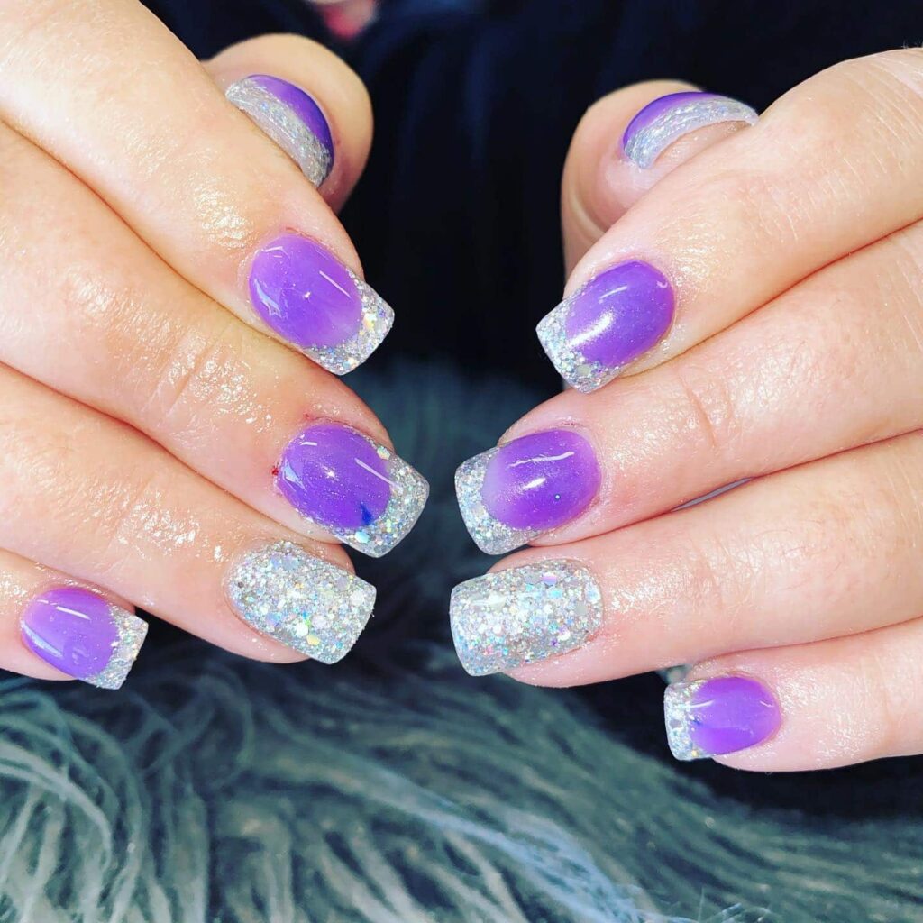 Vibrant purple nails with chunky silver glitter French tips